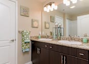 Thumbnail 17 of 29 - A bathroom with brown cabinets and a white door.