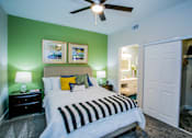 Thumbnail 10 of 44 - A bedroom with a bed, nightstands, and a ceiling fan.