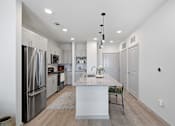 Thumbnail 47 of 55 - A modern kitchen with a center island and stainless steel appliances.