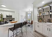 Thumbnail 1 of 48 - A modern kitchen with a dining table and chairs.