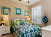 Thumbnail 13 of 29 - A bedroom with a bed, nightstand, and three pictures on the wall.