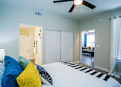 Thumbnail 11 of 44 - A bedroom with a bed, pillows, and a ceiling fan.