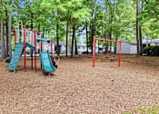 Thumbnail 18 of 48 - A playground with a red swing set and a green slide.