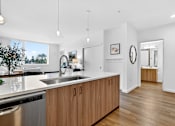 Thumbnail 8 of 33 - A modern kitchen with wooden cabinets and a large window.
