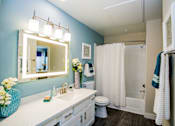 Thumbnail 12 of 44 - A bathroom with a white sink and a mirror above it.