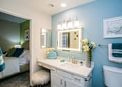 Thumbnail 13 of 44 - A bathroom with a white vanity and a white toilet.