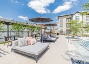 Thumbnail 9 of 24 - an outdoor patio with couches and umbrellas and a pool