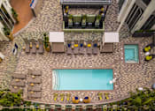 Thumbnail 8 of 34 - A pool surrounded by chairs and umbrellas.