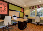 Thumbnail 18 of 29 - A room with a desk and chairs and a clock on the wall.