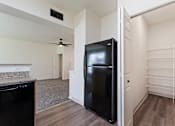 Thumbnail 14 of 36 - A black refrigerator in a kitchen with a fan on the ceiling.