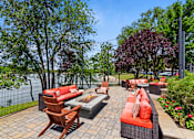 Thumbnail 22 of 52 - A patio with red couches and a fire pit.