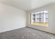 Thumbnail 27 of 36 - Empty room with a large window overlooking a building.