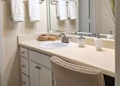 Thumbnail 7 of 20 - A bathroom with a sink, mirror, and towel rack.
