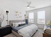Thumbnail 4 of 55 - A bedroom with a bed, nightstand, and a ceiling fan.