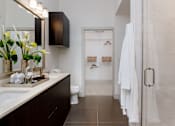 Thumbnail 28 of 46 - A bathroom with a white towel hanging on the door.