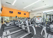 Thumbnail 18 of 30 - A gym with treadmills and exercise equipment.