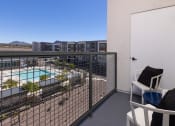 Thumbnail 29 of 59 - a balcony with a pool and buildings in the background at Element 12 Apartments, Henderson NV