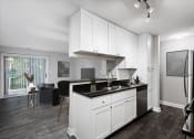 Thumbnail 12 of 22 - a kitchen with white cabinets and a black counter top