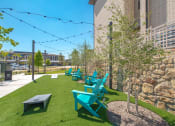 Thumbnail 30 of 35 - a group of blue and green chairs and picnic tables on the grass