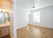 Thumbnail 20 of 44 - A bathroom with wooden floors and a white wall.