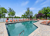 Thumbnail 28 of 52 - A pool surrounded by trees and chairs.