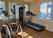 Thumbnail 18 of 19 - A fitness center with a treadmill and elliptical