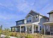 Thumbnail 26 of 51 - a blue house with white trim and a wooden fence