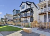 Thumbnail 24 of 51 - an exterior view of an apartment building with a sidewalk and grass