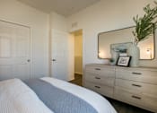 Thumbnail 36 of 38 - a bedroom with a bed and a dresser with a mirror