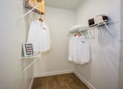Thumbnail 21 of 44 - A white shirt with the word "City" on it hangs on a clothes rack.