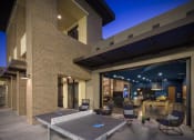 Thumbnail 32 of 34 - a patio with a ping pong table and chairs