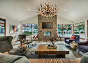 Thumbnail 27 of 48 - Clubhouse lounge with stone fireplace and large windows at Canyon Creek Apartments, Wilsonville
