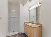 Thumbnail 22 of 36 - A bathroom with a sink, mirror, and shower.
