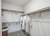Thumbnail 18 of 55 - A white robe is hanging on a clothes rack in a white room.