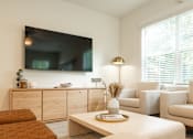 Thumbnail 3 of 15 - A living room with a flat screen TV mounted on the wall.