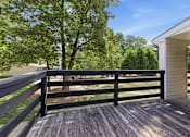 Thumbnail 39 of 48 - A wooden deck with a railing and a house in the background.