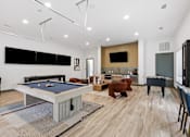 Thumbnail 52 of 55 - A pool table is in the middle of a room with a TV and a fireplace.