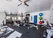 Thumbnail 28 of 44 - A well-equipped gym with a variety of exercise machines and weights.