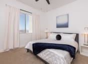 Thumbnail 25 of 59 - a bedroom with a bed and a window with white curtains at Element 12 Apartments, Henderson NV
