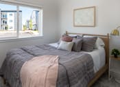 Thumbnail 6 of 27 - Bedroom with a bed, pillows, a blanket, a lamp, and a framed picture on the wall at The Arvon, Vancouver,98662