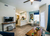 Thumbnail 3 of 44 - A living room with a television and a dining table.