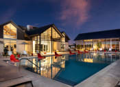 Thumbnail 10 of 26 - a swimming pool in front of a hotel at night