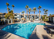 Thumbnail 30 of 44 - A swimming pool surrounded by palm trees and lounge chairs.