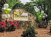 Thumbnail 20 of 20 - A sign for The Reserve surrounded by balloons and flowers.
