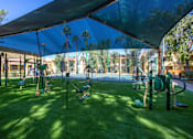 Thumbnail 15 of 18 - A playground with a green canopy and a variety of equipment.