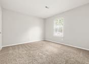 Thumbnail 29 of 48 - A room with a carpeted floor and a window with blinds.