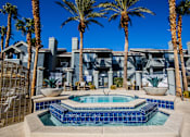 Thumbnail 32 of 44 - A pool surrounded by palm trees and a building in the background.