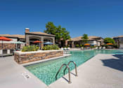Thumbnail 2 of 48 - A pool surrounded by a stone wall with a building in the background.