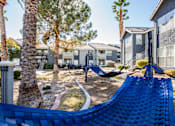 Thumbnail 34 of 44 - A blue hammock is in the foreground of a residential area with houses and palm trees.