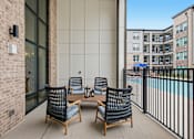 Thumbnail 51 of 55 - A patio with a table and chairs overlooking a pool.